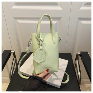Détail du sac seau vert clair avec breloque chiot et texte de mode sur similicuir
