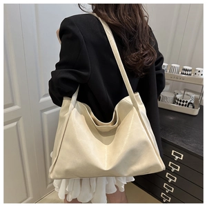 Vue détaillée du grand sac cabas en cuir PU beige porté par un mannequin à l'intérieur