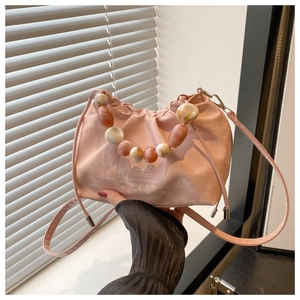 Detail of pink pleated bucket bag with marble bead handle and white text printing