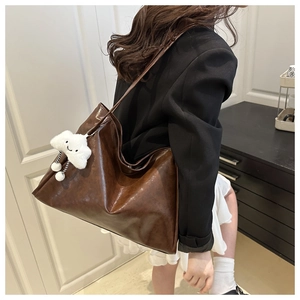 Détail d'un grand sac fourre-tout marron foncé avec un joli pendentif nuage en peluche