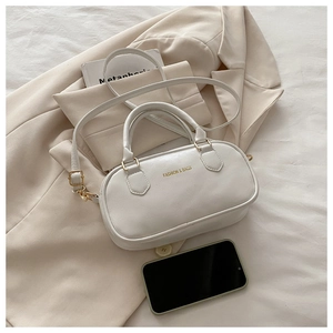 Dettaglio della borsa bianca in pelle PU con fibbie dorate su un blazer beige