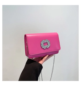 Detail of rose pink mini crossbody bag with a large rhinestone ring buckle and silver chain