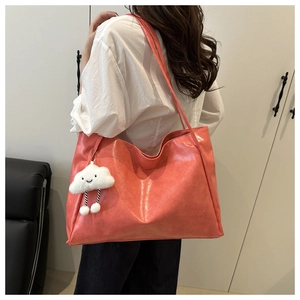 Detail of coral pink tote bag with shiny PU leather texture and cute cloud charm