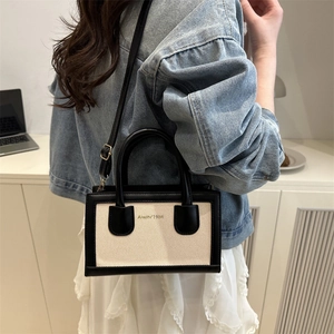 Fashionable woven tote bag in black and white contrast design with leather handles