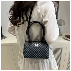 Detail of Boston bag showing blue checkered pattern and white butterfly metal accent