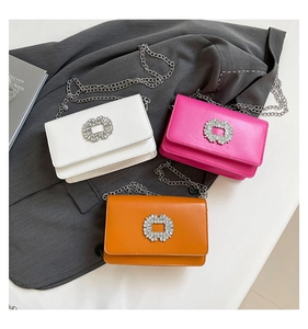 Detailed view of small crossbody bags with rhinestone buckles in white, rose, and orange