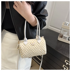 Detail of yellow geometric pattern bag with white butterfly buckle and leather handles