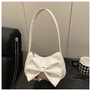 Close-up of white minimalist bow shoulder bag with smooth PU leather texture and zip closure