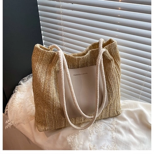 Close-up of a straw tote bag with rope handles and a minimalist FASHION & BAGS patch