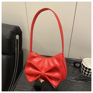 Detailed view of the red PU leather shoulder bag featuring a large decorative bow