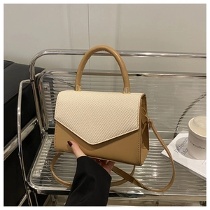Close-up of the beige woven texture and khaki synthetic leather on the small square bag