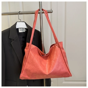 Détail du sac cabas orange corail en cuir ciré souple avec large bandoulière et fermoir aimanté