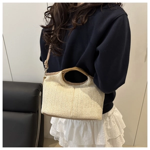 Detail of hand-woven beige tote bag with brown PU leather handles and adjustable strap
