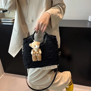 Sac fourre-tout noir en tissu gaufré avec breloque ours porté par un mannequin