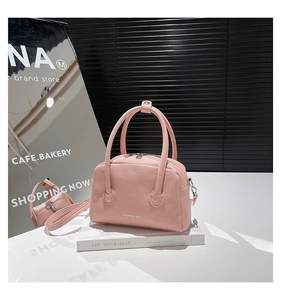 Close-up of pink lychee textured leather tote with silver fashion logo and handles