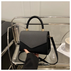 Close-up of black and grey patchwork small square bag with elegant gold metal hardware