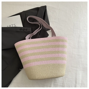 Detail of pink and beige striped woven straw tote bag with lavender shoulder handles
