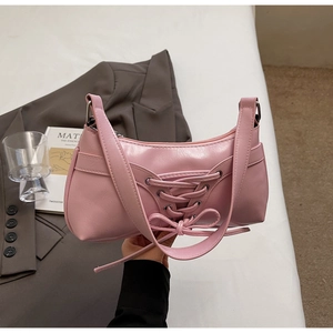 Détail du sac hobo en cuir rose avec dentelle vintage et bandoulière réglable