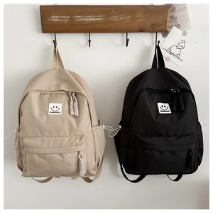 Détail des tirettes de fermeture tressées et du logo sourire sur les sacs à dos en nylon