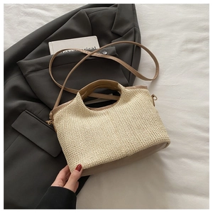 Detail of woven straw handbag with brown leather straps on a minimalist background