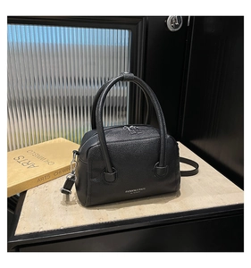 Close-up of black Boston bag showing lychee grain leather texture and silver hardware
