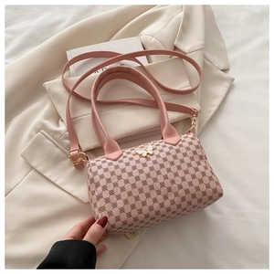 Detailed macro view of pink floral cylinder bag with golden butterfly charm detail