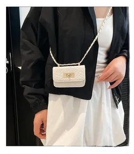 Detail of white quilted mini crossbody bag with golden twist lock and chain strap