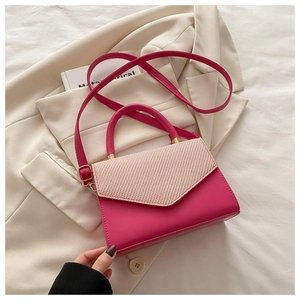 Detail of fuchsia leather crossbody bag with beige woven flap and gold hardware accents