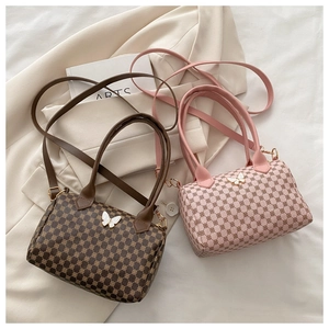 Detail view of coffee and pink Boston bags featuring vintage prints and butterfly metal buckle