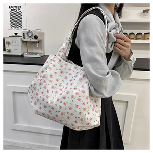 Close-up of lightweight tote bag featuring a pink rose floral pattern on off-white canvas
