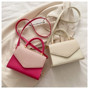 Detail of woven patchwork small square bags in rose red and cream white leather