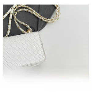 Close-up detail of the cross-woven leather texture on the white chain shoulder bag