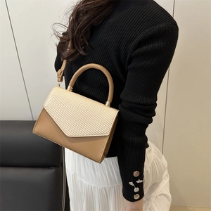 Brown leather and beige woven flap handbag with top handle and adjustable shoulder strap