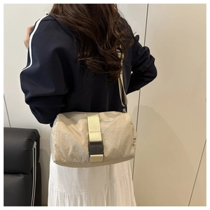 Beige oxford crossbody bag shown on model with adjustable strap and buckle detail
