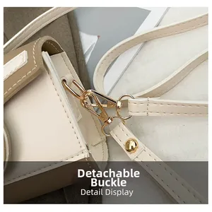 Detailed close-up of golden metal detachable buckle on beige contrast crossbody bag
