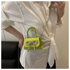 Vue détaillée du mini sac bandoulière vert fluo avec un nœud en strass brillant