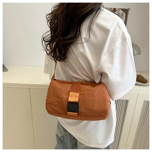 Detail view of the orange oxford fabric shoulder bag with buckle strap on model