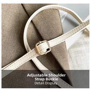 Detail display of cream leather shoulder strap and light gold adjustable metal buckle