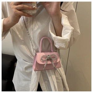 Détail du mini sac rose avec nœud en strass et fine bandoulière en chaîne