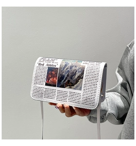 Détail d'un petit sac carré avec imprimé journal rétro et boucle métallique dorée