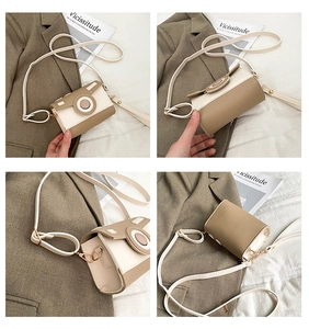 Detail view of khaki and beige camera-shaped crossbody bag with gold hardware accents