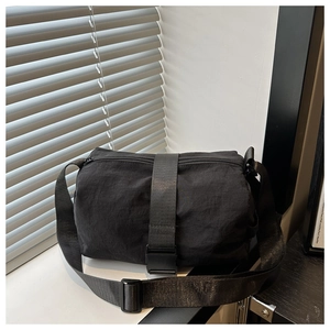Detail view of black waterproof nylon crossbody bag with adjustable strap and buckle