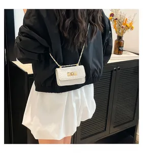Detail showing white animal textured leather bag with gold buckle and chain strap
