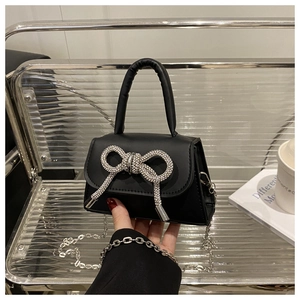 Détail du mini sac bandoulière noir orné d'un nœud étincelant en strass argentés