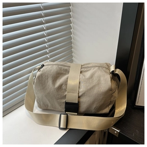 Detail of beige nylon crossbody bag showing the durable fabric and black utility buckle