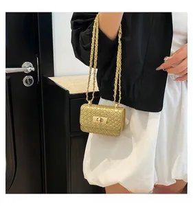 Detail of gold woven chain bag with metallic finish and elegant gold twist lock clasp