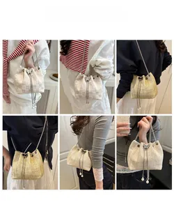 Detail view of woven drawstring bucket bag with pearl tassels and chain strap options