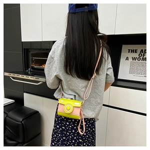 Chic camera-shaped mini crossbody bag in yellow and pink PU leather worn by a model