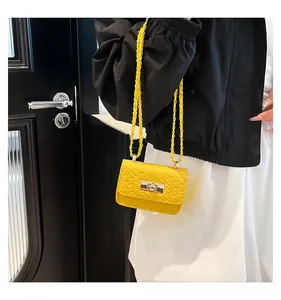Detail of yellow woven texture mini shoulder bag with gold metal buckle and chain strap