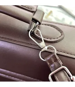 Detailed macro view of detachable silver metal hardware hooks and brown leather strap